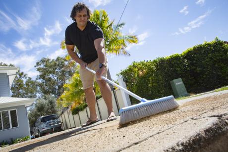 Northgate resident Tyrone Williams 3, saves water by sweeping his driveway rather than use a hose.