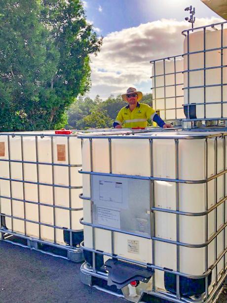 Seqwater Supply Operator Matthew Alderwick standing next to the intermediate bulk containers that are being auctioned off to provide funds to Beyond Blue