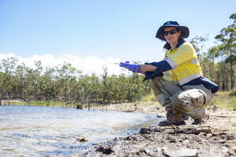 Seqwater Environmental Coordinator Nicolette Osborne takes a water sample at Hinze Dam using an eDNA sampling kit