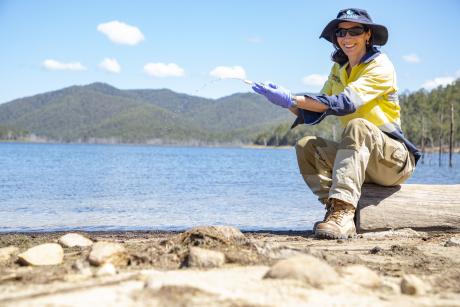 Seqwater Environmental Coordinator Nicolette Osborne takes a water sample at Hinze Dam using an eDNA sampling kit