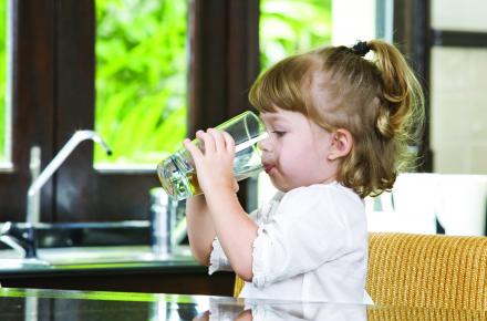 Little girl drinking a glass of quality tap water
