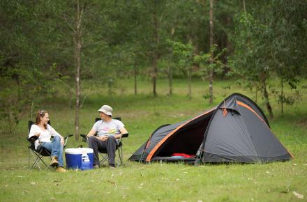 A couple camp in a grassy location