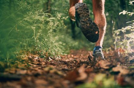 Man with muscular calves running on nature trail