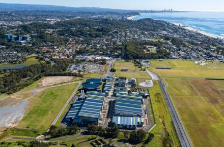 An aerial shot of the plant, with its distinctive blue and yellow rooves and the beach stretching into the background