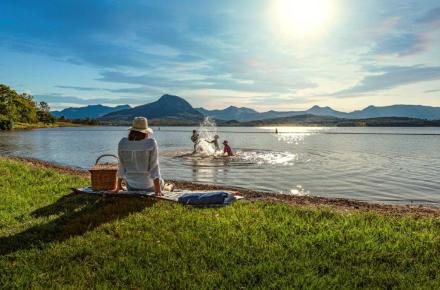 A parent watching their children play in the lake.